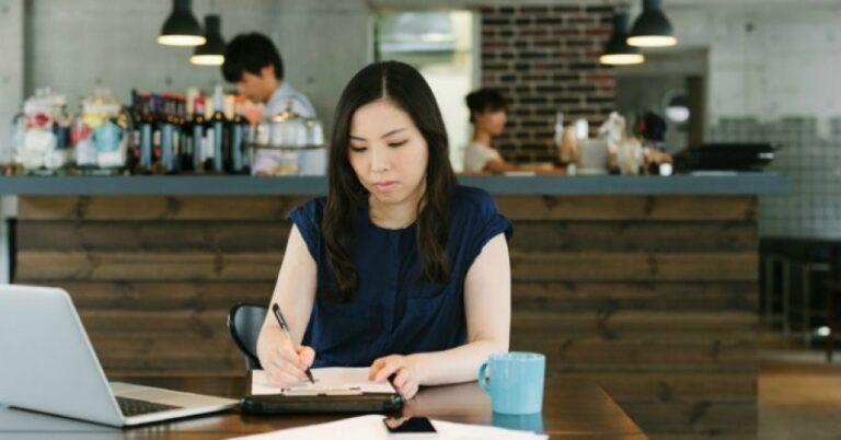 a woman working in a bar and writing in her notebook