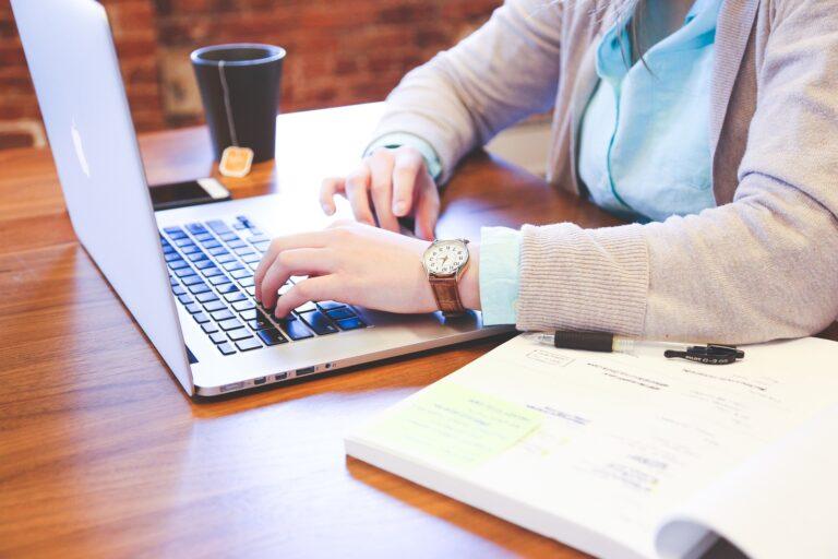 a woman is working on her laptop