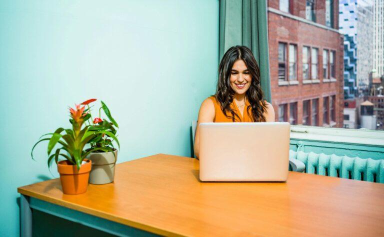 a woman is working on her laptop